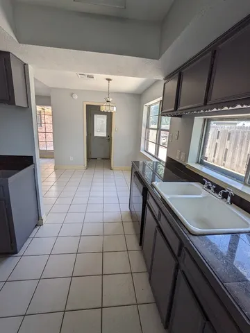 a kitchen with a sink a stove cabinets and a window
