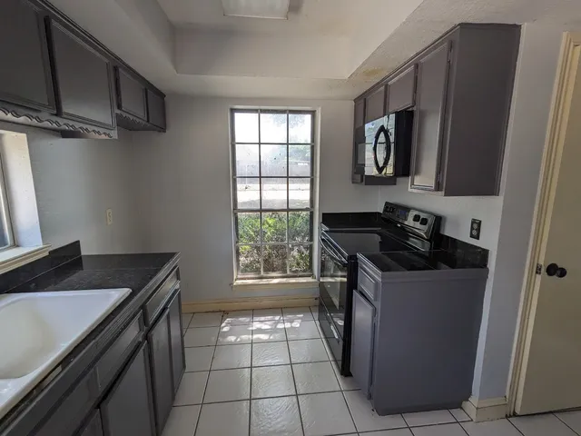 a kitchen with granite countertop a stove and a sink