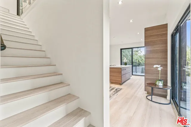 a view of a hallway with wooden floor and dining room