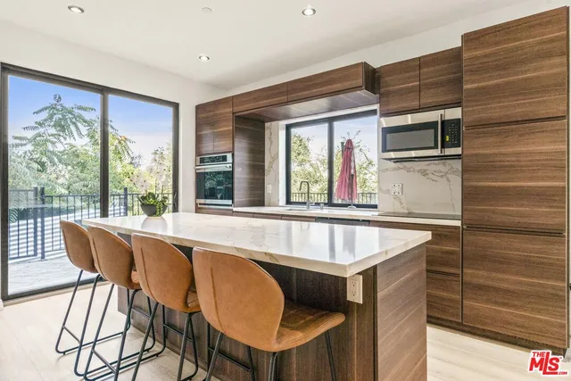 a kitchen with kitchen island a large window a sink and counter space