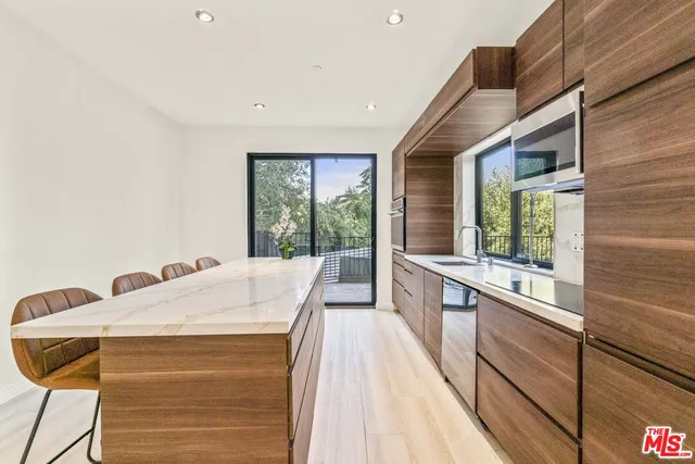 a large kitchen with kitchen island a large window in it