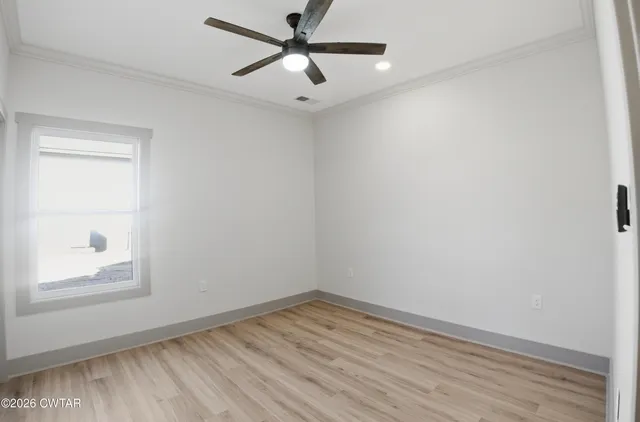 an empty room with a window and a ceiling fan