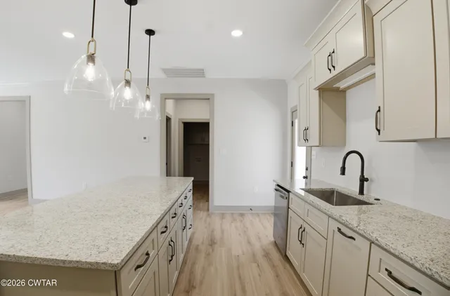 a kitchen with stainless steel appliances granite countertop a sink a refrigerator and a stove