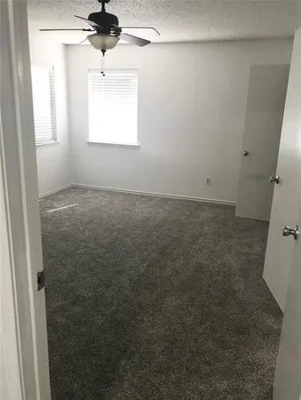 en empty room with windows and fan