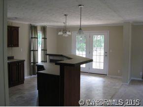 259 Ernest Rogers Road Clyde, NC 28721 - Photo 6 of 12 a kitchen with kitchen island granite countertop a stove a refrigerator a sink and a dining table with wooden floor