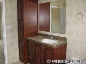 259 Ernest Rogers Road Clyde, NC 28721 - Photo 7 of 12 a bathroom with a granite countertop sink and a mirror