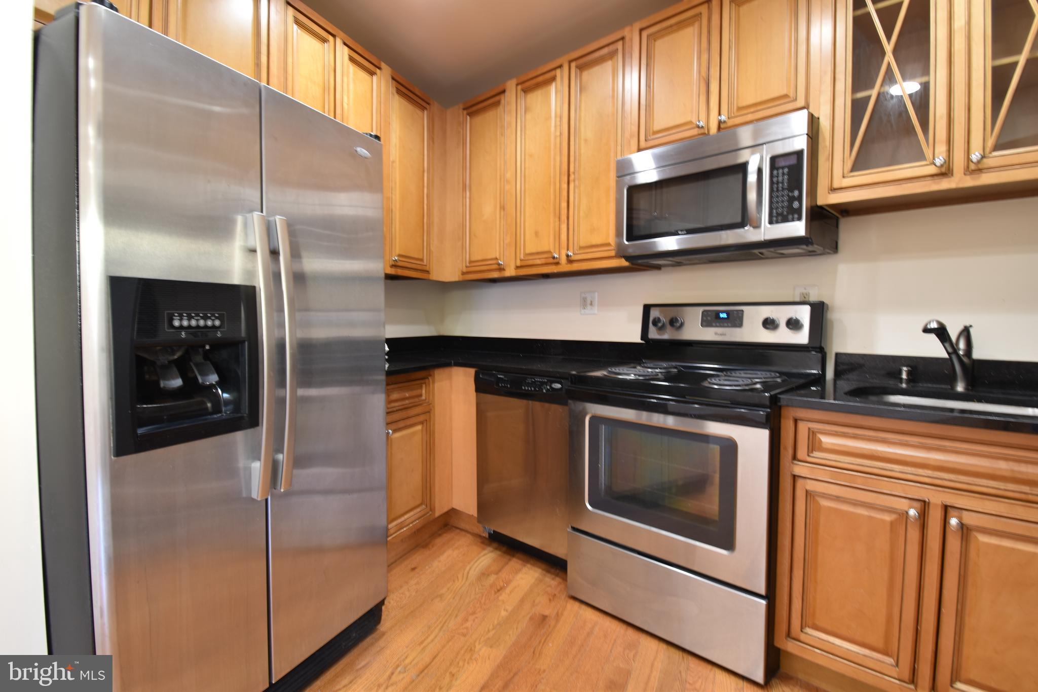 a kitchen with stainless steel appliances granite countertop a stove a microwave and a sink