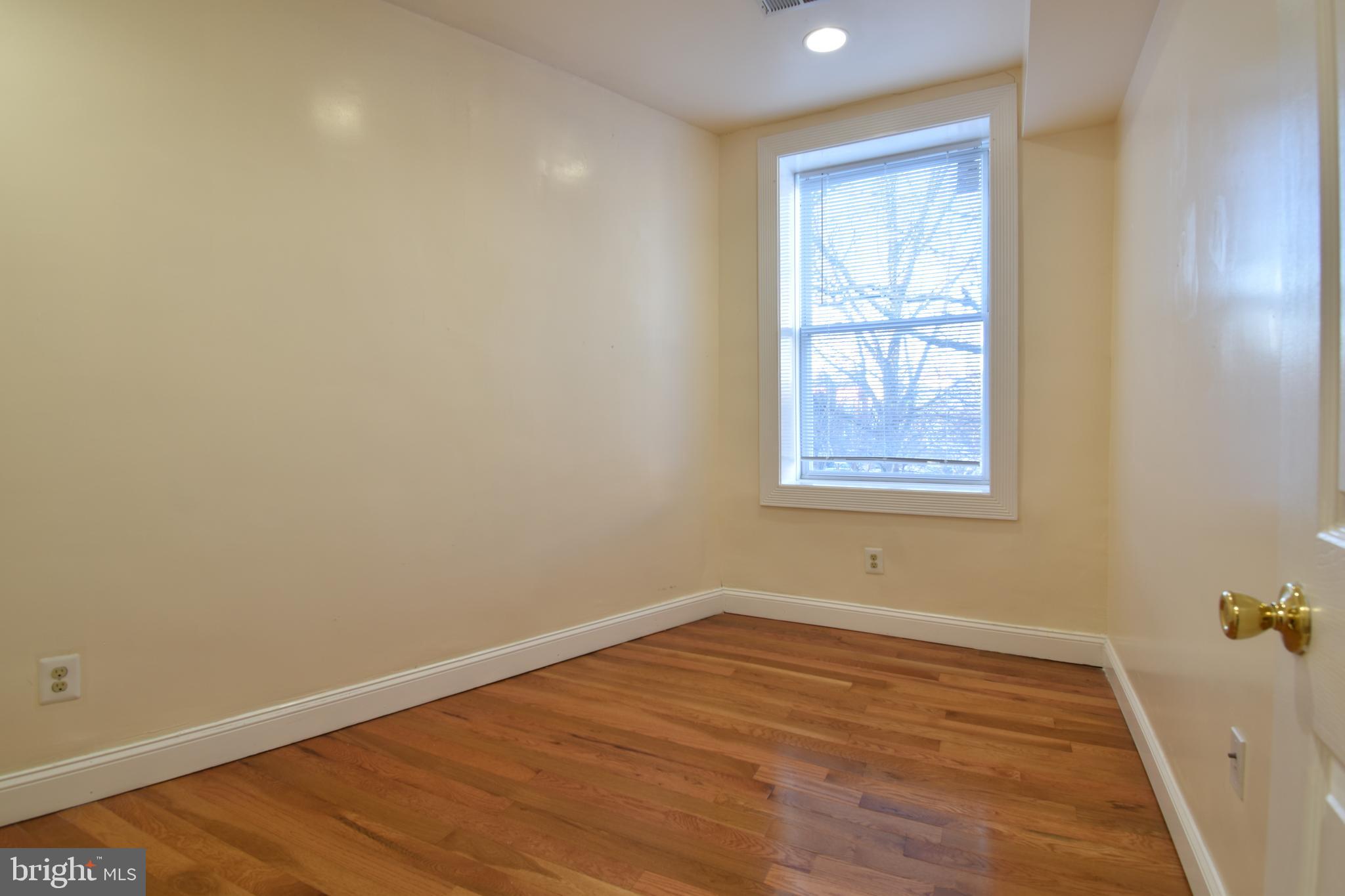 3408 Sherman Avenue Northwest, Unit 202 Washington, DC 20010 - Photo 14 of 20 an empty room with wooden floor and windows