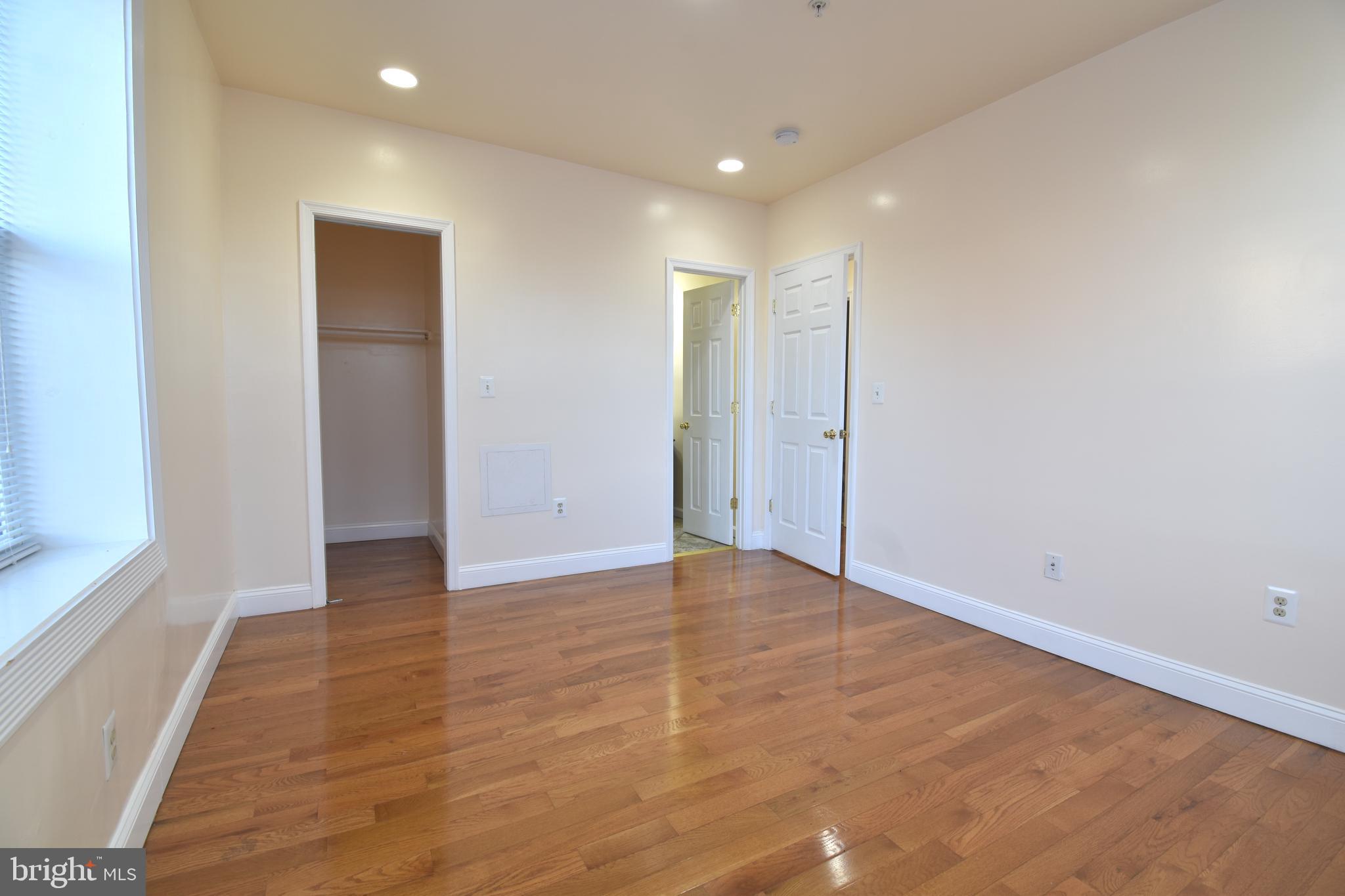 3408 Sherman Avenue Northwest, Unit 202 Washington, DC 20010 - Photo 16 of 20 a view of an empty room with wooden floor and a window