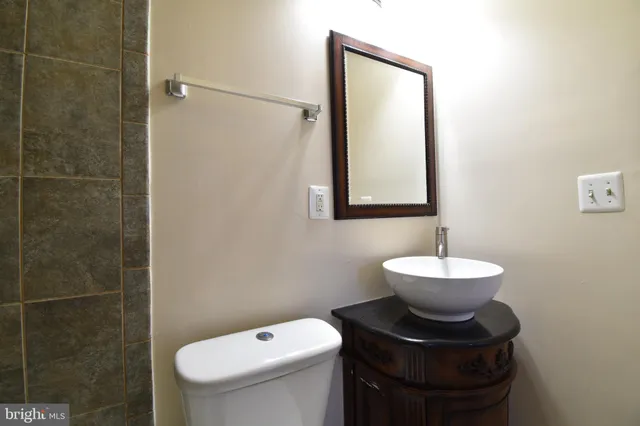 a bathroom with a toilet sink and mirror