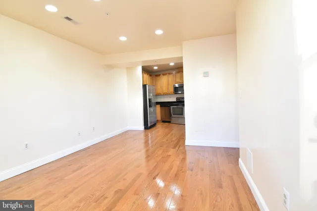 a view of empty room with wooden floor