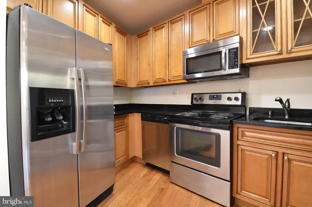 a kitchen with stainless steel appliances granite countertop a stove a microwave and a refrigerator