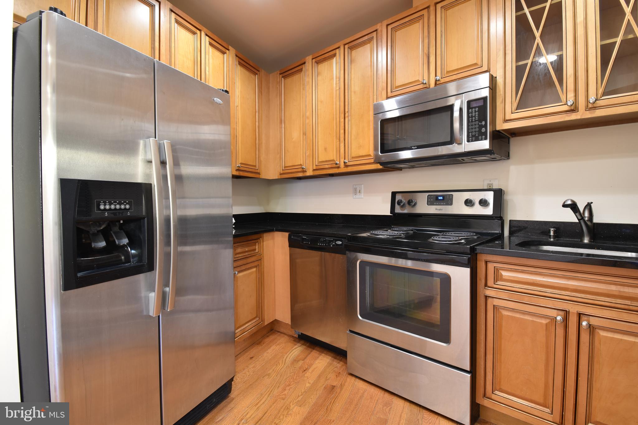 3408 Sherman Avenue Northwest, Unit 202 Washington, DC 20010 - Photo 9 of 20 a kitchen with stainless steel appliances granite countertop a stove a microwave and a refrigerator