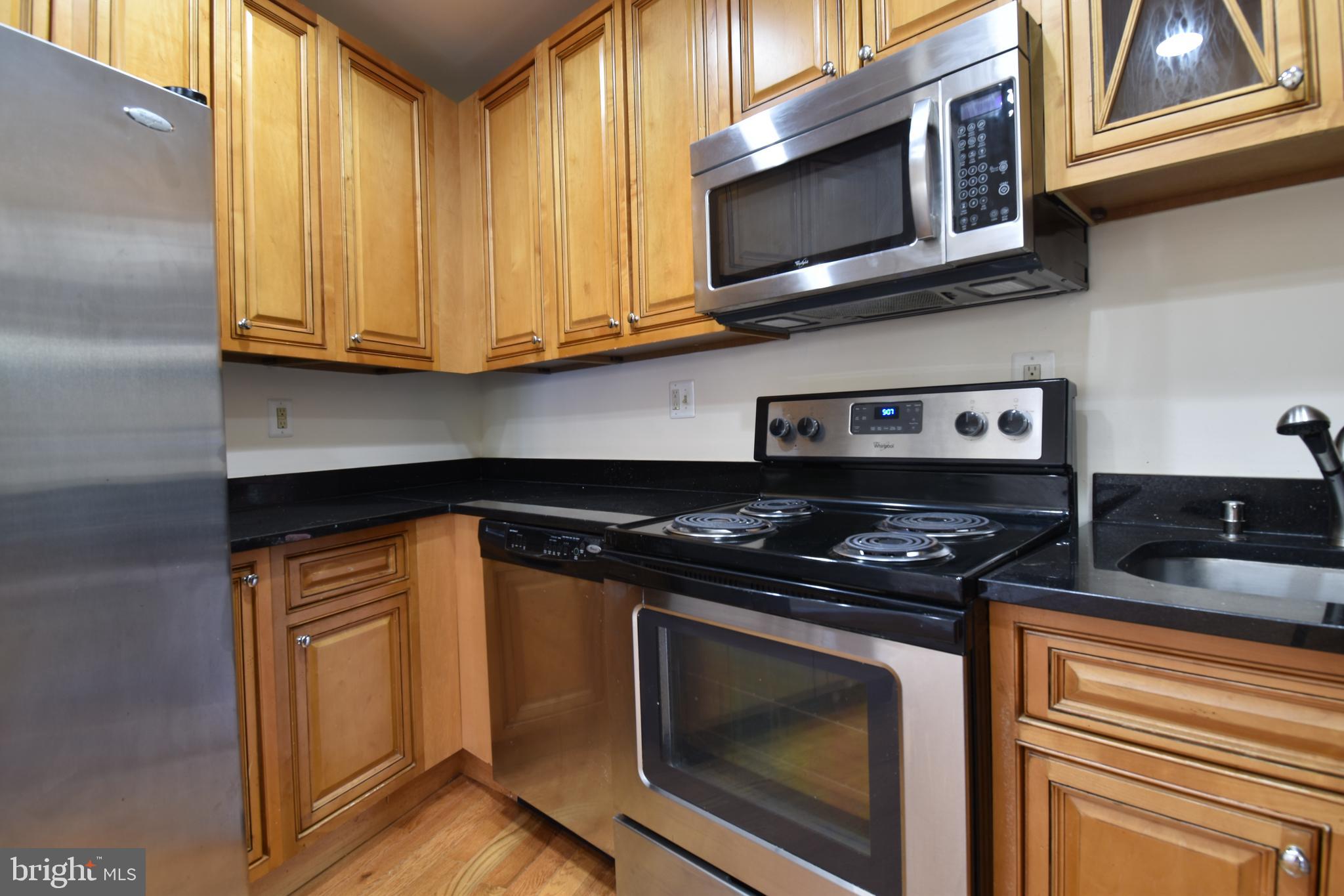 3408 Sherman Avenue Northwest, Unit 202 Washington, DC 20010 - Photo 10 of 20 a kitchen with stainless steel appliances granite countertop white cabinets and a stove top oven