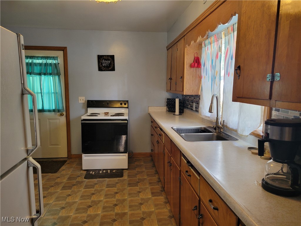 101 Eastport Road Scio, OH 43988 - Photo 7 of 30 Kitchen featuring backsplash, sink, and white appliances