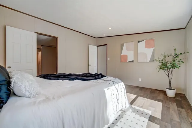 a bedroom with a large bed and a potted plant