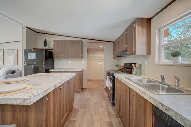 a kitchen with a stove sink and cabinets