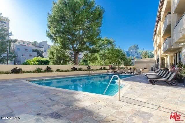 10982 Roebling Avenue, Unit 109 Los Angeles, CA 90024 - Photo 18 of 20 a view of a swimming pool with lounge chair and a fire pit