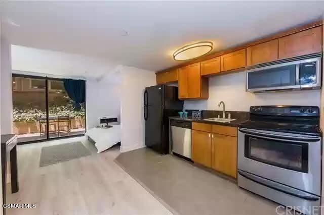 10982 Roebling Avenue, Unit 109 Los Angeles, CA 90024 - Photo 3 of 20 a kitchen with stainless steel appliances granite countertop a stove a sink and a refrigerator
