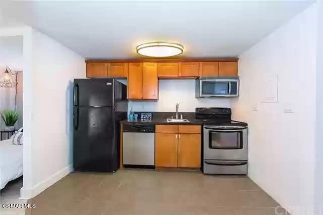 10982 Roebling Avenue, Unit 109 Los Angeles, CA 90024 - Photo 5 of 20 a kitchen with stainless steel appliances granite countertop a refrigerator and a sink