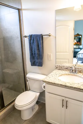 a bathroom with a granite countertop toilet sink and mirror