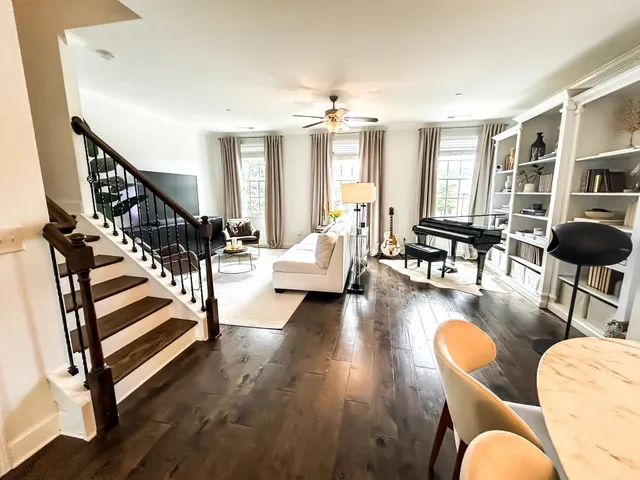 a living room with furniture and a dining table with wooden floor
