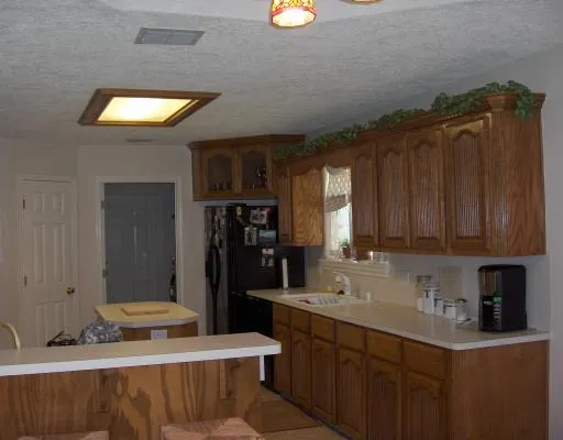 a kitchen with stainless steel appliances kitchen island granite countertop a refrigerator and a sink