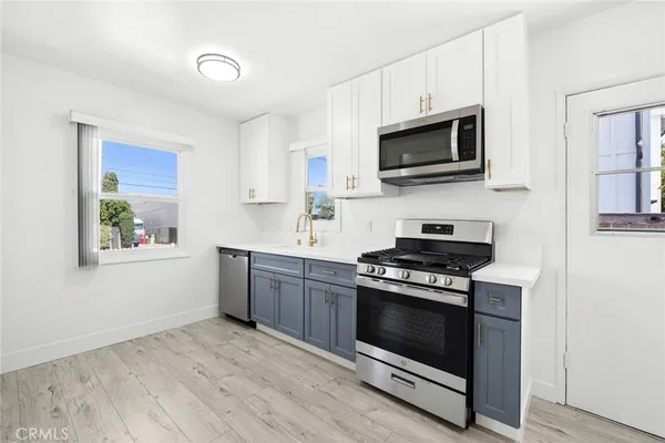a kitchen with stainless steel appliances a stove a microwave and sink