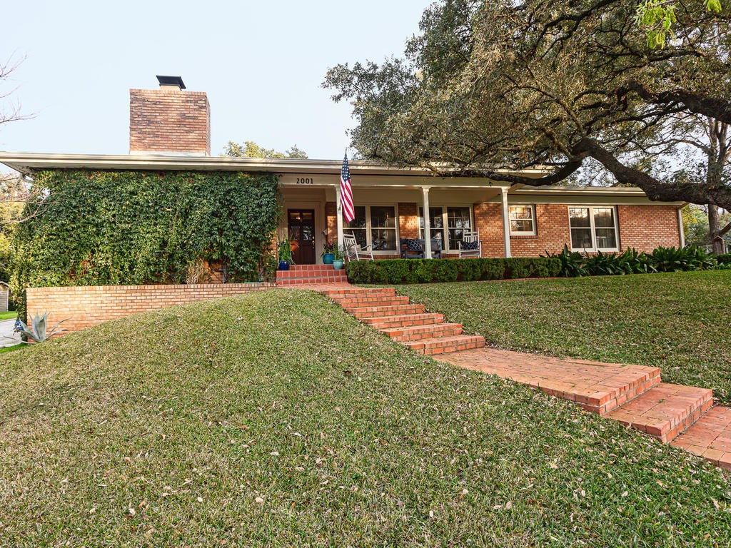 a front view of a house with a yard and trees