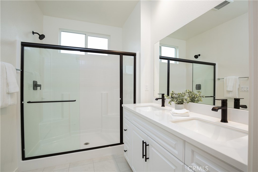 12232 Akira Drive Stanton, CA 90680 - Photo 19 of 39 a bathroom with a double vanity sink and mirror