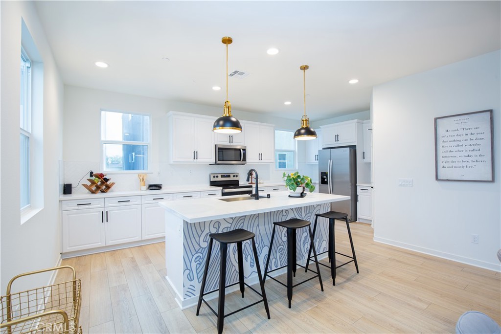 12232 Akira Drive Stanton, CA 90680 - Photo 6 of 39 a kitchen with stainless steel appliances a stove a sink a refrigerator and a center island