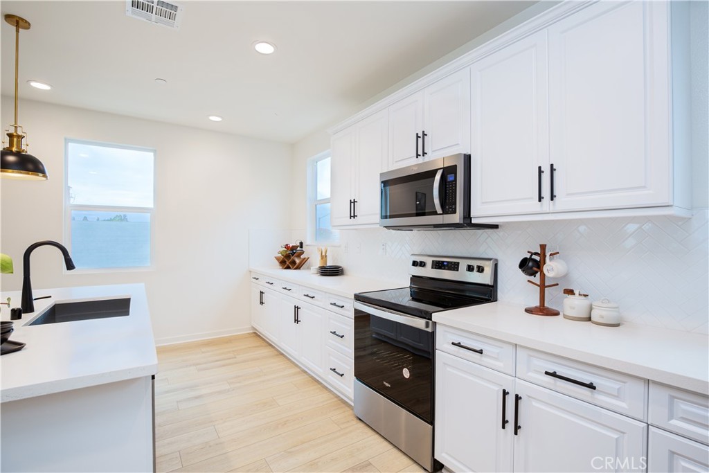 12232 Akira Drive Stanton, CA 90680 - Photo 8 of 39 a kitchen with granite countertop a sink stainless steel appliances and white cabinets