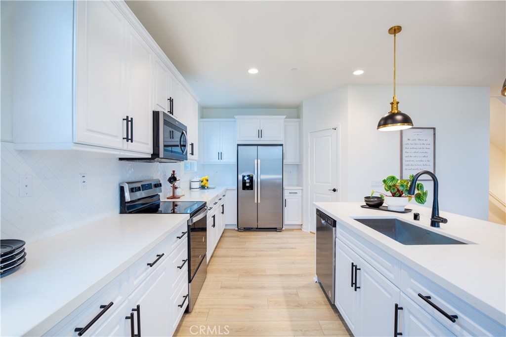 12232 Akira Drive Stanton, CA 90680 - Photo 9 of 39 a kitchen with stainless steel appliances a sink a stove and a refrigerator