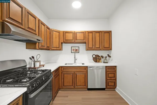 a kitchen with stainless steel appliances granite countertop a sink stove and cabinets