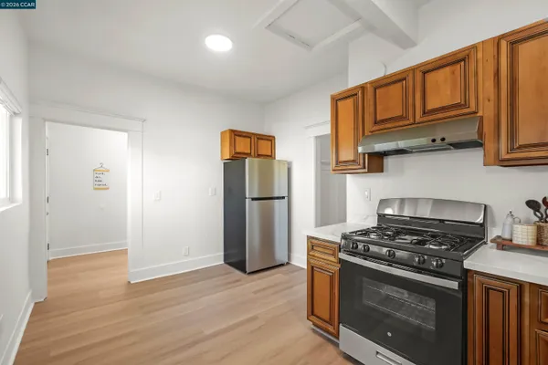 a view of an empty room with wooden floor and a cabinet