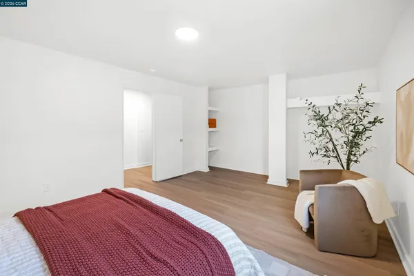 a view of a hallway with wooden floor and a potted plant