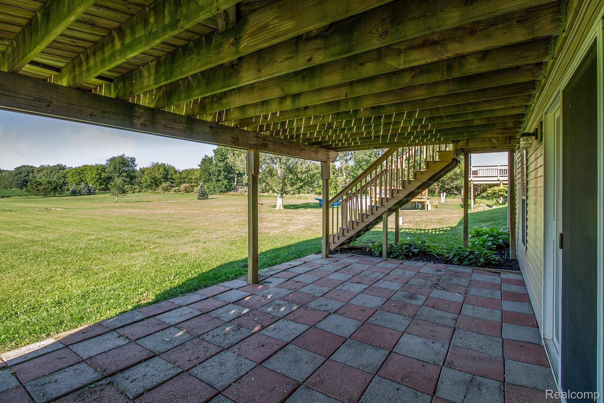 5040 West Coon Lake Road Howell, MI 48843 - Photo 20 of 27 Patio Under Deck and Stairway to Back yard