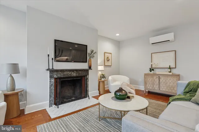 a living room with furniture a flat screen tv and a fireplace