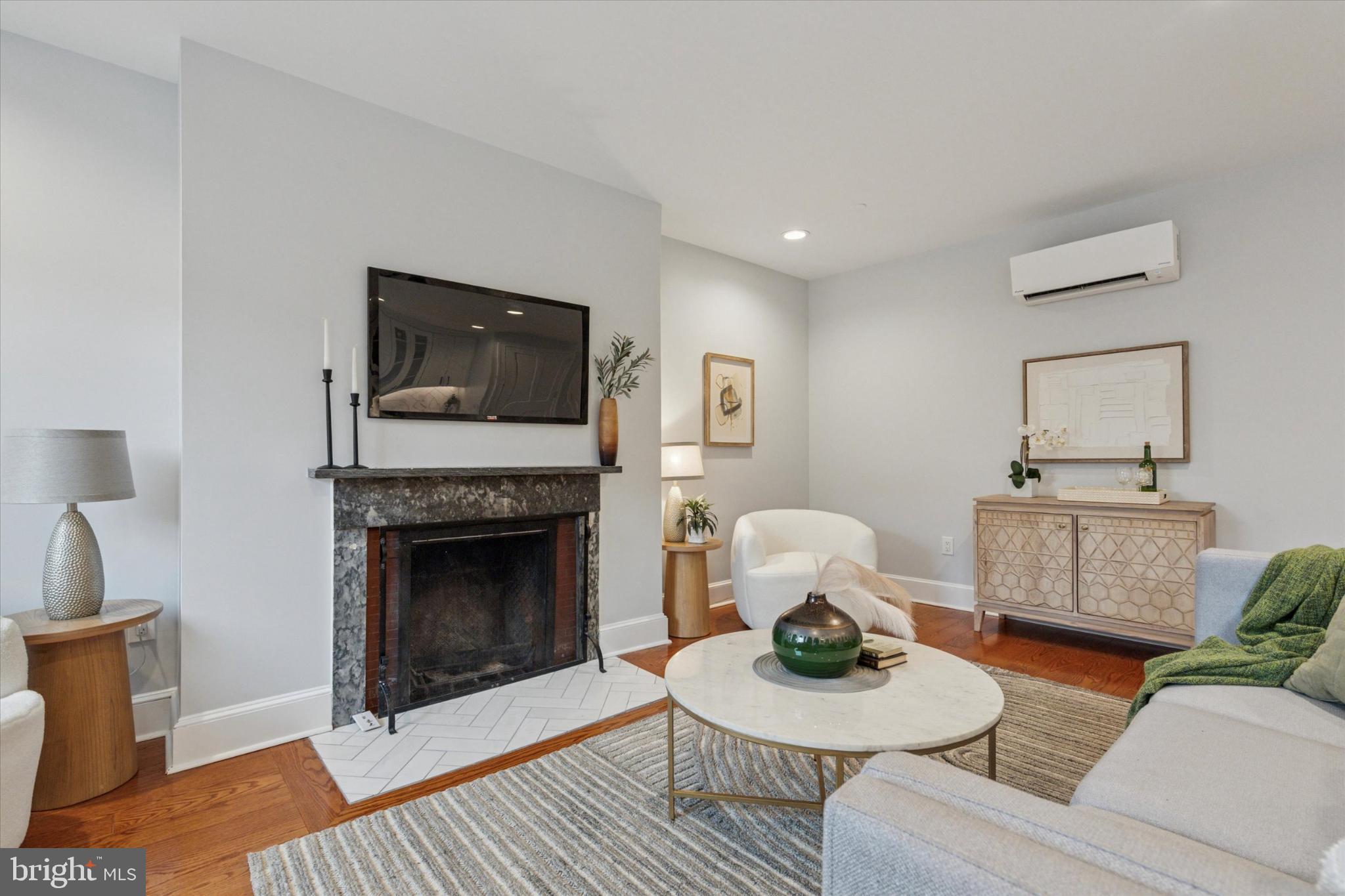1215 Spruce Street, Unit 301 Philadelphia, PA 19107 - Photo 12 of 27 a living room with furniture a flat screen tv and a fireplace