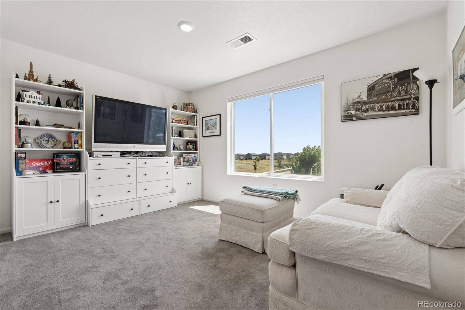 7307 Animas Avenue Frederick, CO 80530 - Photo 23 of 49 a living room with furniture a flat screen tv and kitchen view