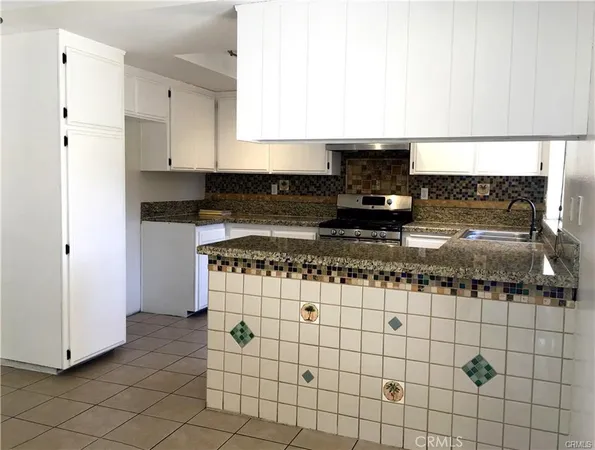 a kitchen with granite countertop a stove sink and cabinets