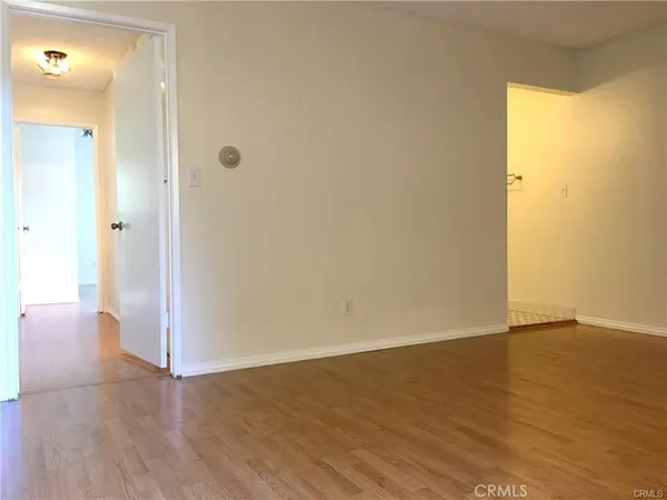 a view of a room with wooden floor and a window