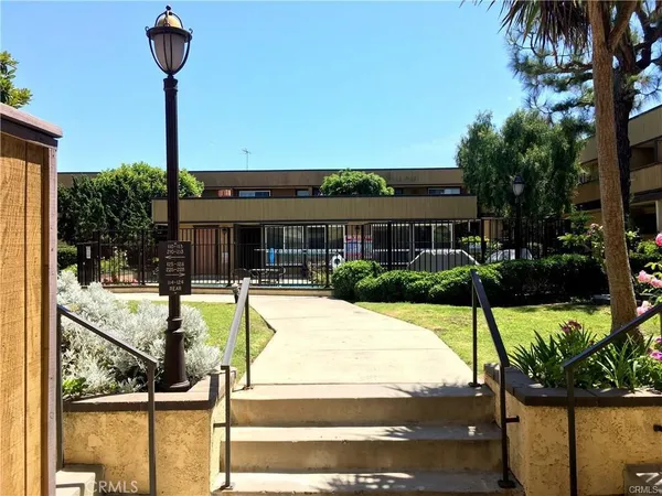 a view of a house in front of a yard with potted plants