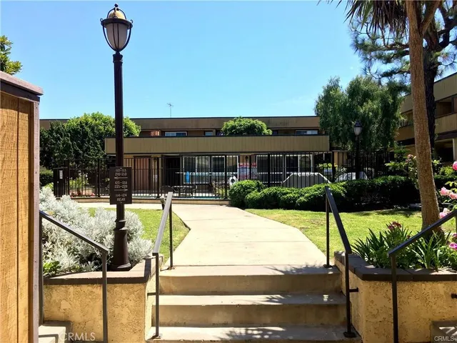 a view of a house in front of a yard with potted plants