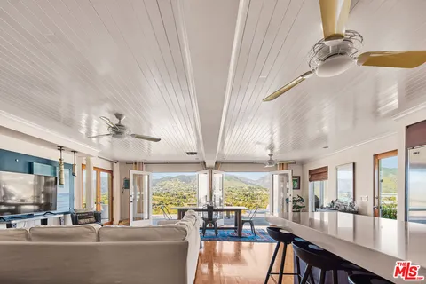 a living room with furniture a table and kitchen view
