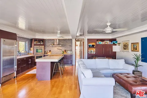 a kitchen with stainless steel appliances granite countertop a sink dishwasher stove and refrigerator with wooden floor