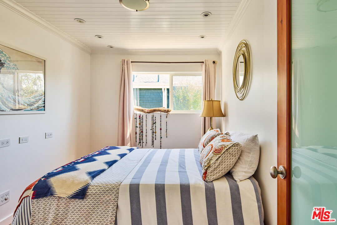 29500 Heathercliff Road, Unit 196 Malibu, CA 90265 - Photo 19 of 29 a bedroom with a bed and wooden floor