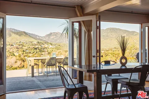 a view of a chairs and table in the balcony