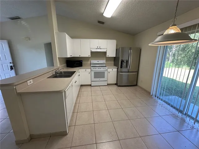 a kitchen with a stove a sink dishwasher and a refrigerator