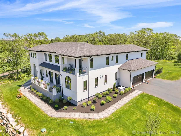 aerial view of a house with a big yard and large trees